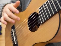 Ein Kind spielt Gitarre.