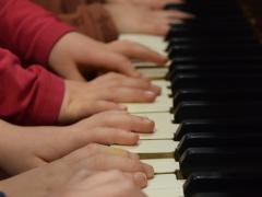 Kinderhände auf einem Klavier.