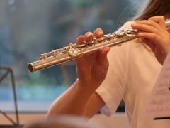 Ein Mädchen spielt Querflöte.