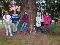 Das Ensemble "Easy going" steht an einem dicken Baum vor der Schule.