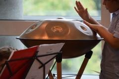 Eine Person spielt auf einem Klanginstrument.
