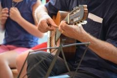 Eine Person spielt auf einer Gitarre.