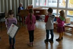 Mehrere Kinder stehen vor einem Klavier.