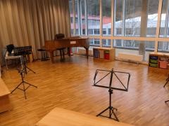 In einem Raum der Musikschule stehen Bänke, Notenständer und ein Flügel.