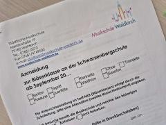 Ein Anmeldeformular liegt auf dem Tisch.