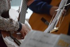Ein Kind spielt auf einer akkustischen Gitarre.