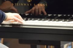 Ein Lehrer spielt auf dem Piano.
