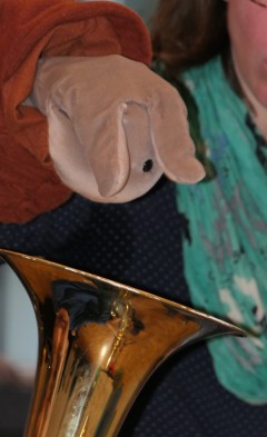 Eine Trompete mit einer Hasen-Handpuppe.