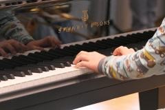Ein Kind spielt an einem Piano.