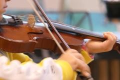 Ein Kind spielt auf einer Violine.