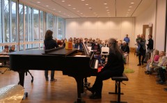 Musiklehrer halten eine Rede vor Kindern und Eltern.