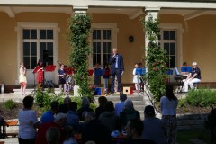 Der Schulleiter begrüßt die Gäste und eröffnet das Fest vor der Musikschule.