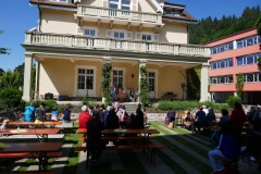 Gäste sitzen vor der Musikschule und hören Musik.