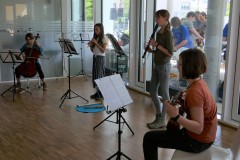 Junge Musiker spielen Flöte, Klarinette, Cello und Gitarre.