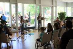 Junge Musiker spielen Flöte, Gitarre und Cello im Ensemble