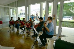 Ein Gitarrenensemble spielt vor den Gästen.
