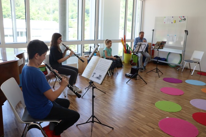 Schüler musizieren gemeinsam mit ihrem Musikleher.