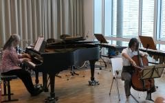 Eine Cellospielerin wird von ihrer Lehrerin am Flügel begleitet.