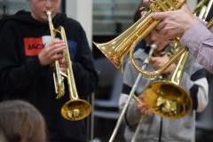 Verschiedene Musiker blasen in ihre Trompeten.