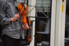Ein Mann streicht seine Violine mit dem Bogen.