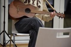 Ein Mann sitzt mit seiner Gitarre.