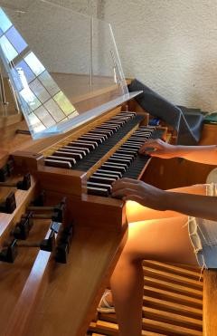 Zwei Hände spielen auf der Orgel.
