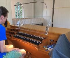 Ein Mann nimmt eine Sitzhaltung ein, um auf der Orgel zu spielen.