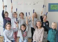 Eine Gruppe Kinder halten ihre Blockflöten in der Luft nach Oben.
