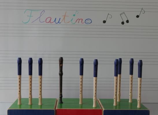 Die Flöten des Ensembles Flautino sind vor einer Tafel aufgestellt, auf der Tafel steht "Flautino".