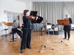 Ein Musiklehrer-Trio bestehend aus einer Flügelspielerin, Violinistin und Saxophonspielerin