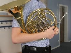 Jugendlicher Schüler hält sein Horn.