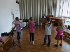 Vier junge Blockflötenschüler*innen werden von ihrer Lehrerin am Klavier begleitet.