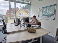 Silke Volk sitzt am Schreibtisch und arbeitet am Computer.