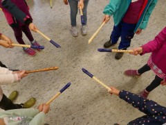 Viele kleine Kinder halten ihre Blockflöten als Stern zusammen.