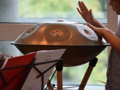 Junger Schüler spielt auf einer Handpan.