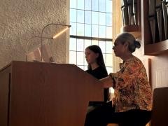 Eine Schülerin sitzt mit ihrer Lehrerin an der Kirchenorgel.