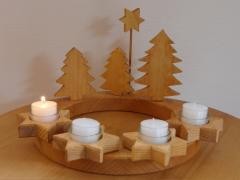 Adventskranz mit einer brennenden Kerze.
