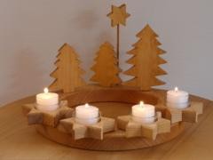 Adventskranz mit vier brennenden Kerzen.